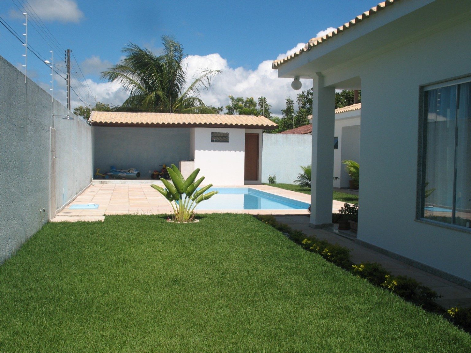 Área externa de imóvel com jardim e piscina