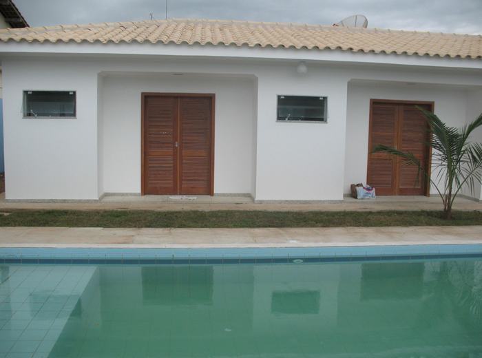 Área da piscina e fachada lateral do imóvel concluído
