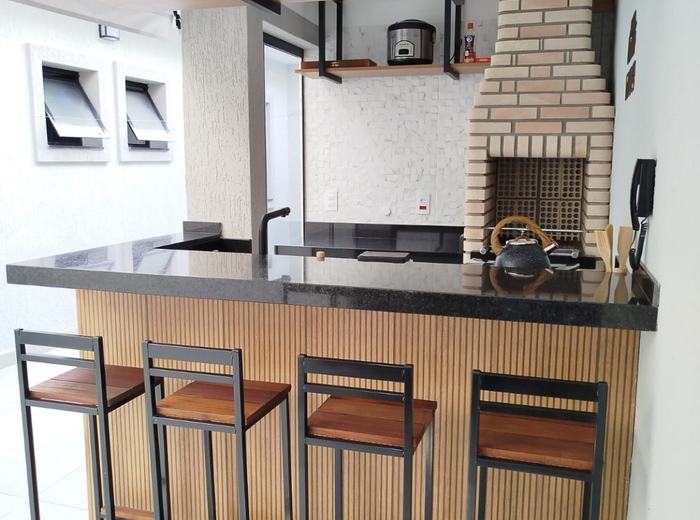 Espaço gourmet na área externa com bancada e banquetas
